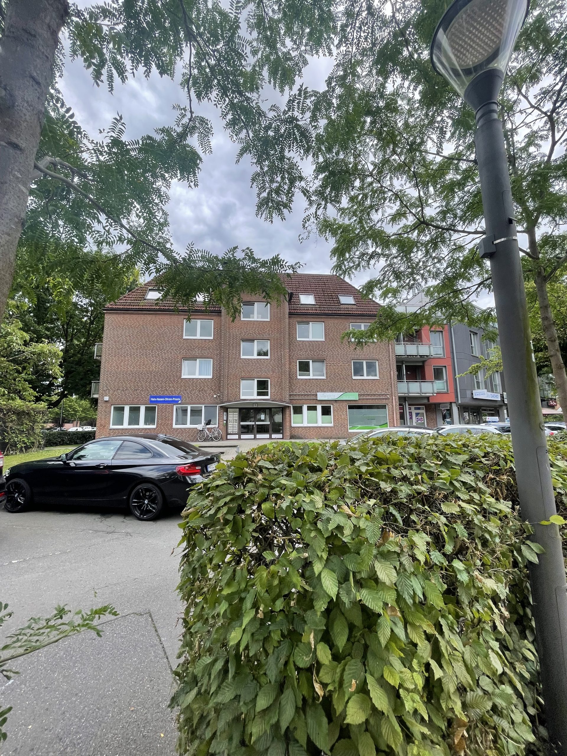 Diese Büro- und Praxisfläche befindet sich im barrierefrei zugänglichen Erdgeschoss eines Wohn- und Geschäftshauses aus dem Baujahr 1986/2007 unweit der belebten Einkaufszone Niendorf-Markt (Tibarg). Auf rund 156 Quadratmetern praktiziert derzeit eine HNO-Arztpraxis, welche die funktionale Mietfläche zum Jahreswechsel 2025/26 aus Expansionsgründen an den Vermieter zurückgeben wird. Die Räumlichkeiten umfassen nach einem Umbau im Jahr 2015 gegenwärtig einen Empfang, drei Behandlungsräume, zwei mietereigene Akustikkabinen, ein Labor / Sterilisationsraum sowie eine Pantry mit Aufenthaltsraum zum Verweilen. Die Praxis erstreckt sich über die linke Hälfte des Erdgeschosses und ist so konzipiert, dass ein funktionaler Workflow gewährleistet ist. Die praktizierenden Ärzte schätzen neben der guten Erreichbarkeit der Adresse Zum Markt 1a in Hamburg-Niendorf auch die im selben Haus ansässige Logopädiepraxis und den Laden eines Hörgeräteakustikers zur Gewinnung von Synergien. Stellplätze sind in der hauseigenen Tiefgarage für eine separate Anmietung verfügbar. Ein kleiner Abstellraum ist der Praxisfläche ebenfalls zu geordnet. 